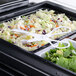 White plastic Fineline salad tongs serving a salad in a tray.