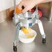 A person using a Vollrath Redco Wedgemaster to cut lemons into a bowl.