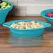 A Fiesta turquoise oval china baker with salad and pasta in it.