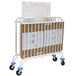 A white L.A. Baby metal folding crib with blue wheels and a mattress.