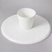 A white cake stand with a white bowl on top.