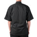 A man wearing a Mercer Culinary black chef jacket with short sleeves.