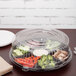 A clear plastic Fineline container with vegetables and a fork.