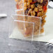 A clear plastic Fineline Tiny Temptations tumbler with food inside and a fork.