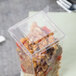A clear plastic container with food inside sitting on a table.