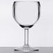 A clear GET SAN plastic wine glass on a white surface.