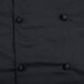 A close up of a black Mercer Culinary chef jacket with cloth knot buttons.