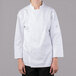 A woman wearing a white Mercer Culinary long sleeve chef jacket.