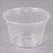 A clear plastic Dart souffle cup on a white surface.