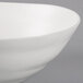 A close up of a 10 Strawberry Street white stoneware serving bowl with a curved edge.
