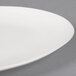 A close-up of a 10 Strawberry Street white stoneware plate with a matte wave rim.