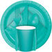 A teal lagoon table cover with a teal cup, spoon, fork, and knife on a plate.