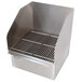 A stainless steel floor mounted mop sink with side splash guards and a grate.