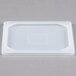 A white Flexsil high-heat silicone lid on a white rectangular surface.