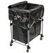 A black Rubbermaid laundry cart on wheels with a black bag inside.