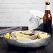 An American Metalcraft stainless steel seafood tray filled with oysters and lemons on a table.