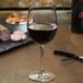 A Reserve by Libbey wine glass filled with red wine on a table.