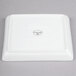 A white square Libbey porcelain tray with a black circle on it.