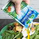 A hand holding a Hidden Valley Blue Cheese Dressing packet over a salad