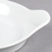 A close-up of a Libbey Aluma White Porcelain Handled Dish on a gray surface.
