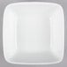 A white square bowl on a gray surface.
