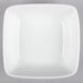A Libbey Chef's Selection white square bowl on a gray surface.