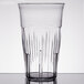 A close-up of a Carlisle clear plastic tumbler with a straight rim.