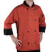 A man wearing a Chef Revival spice orange chef jacket with 3/4 sleeves.