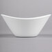 A close-up of a Libbey white porcelain infinity bowl with a curved edge.