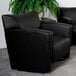 A Flash Furniture black leather club chair in a lounge area.