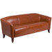 A brown leather couch with wooden legs.
