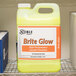 A yellow and orange Noble Chemical container of Brite Glow laundry emulsion on a shelf.