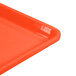 A close up of a Cambro citrus orange dietary tray with a plastic handle.