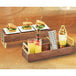 A Cal-Mil walnut wood and brass reversible riser on a table with a tray of food and drinks.