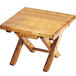 A Cal-Mil Madera rustic pine folding riser with two legs on a wooden table.