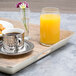A Cal-Mil hickory melamine room service tray with coffee, orange juice, and tea on it.
