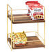 A Cal-Mil two tier wooden and brass merchandiser shelf with food on it.