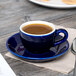 A blue Tuxton cappuccino cup of coffee on a saucer.