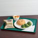 A teal Cambro dietary tray with a sandwich, broccoli, and potato chips.