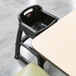 A black Rubbermaid high chair with a strap for babies.