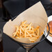 French fries in a wire cone basket lined with a Bagcraft Packaging EcoCraft paper.