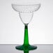 A clear plastic margarita glass with a green stem.