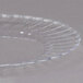 A WNA Comet clear plastic plate with a wavy edge.