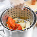 A Vollrath Wear-Ever fryer pot with a lobster and corn in it.