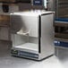 A silver rectangular Amana heavy duty commercial microwave with a handle.