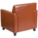 A Flash Furniture brown leather chair with wooden legs.