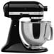 A KitchenAid black and silver countertop mixer with a glass bowl.