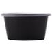 A black Newspring oval souffle container with a clear lid.