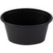 A black plastic oval souffle cup with a clear lid on a white background.