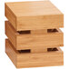A stack of Cal-Mil bamboo square crate risers on a wood surface.